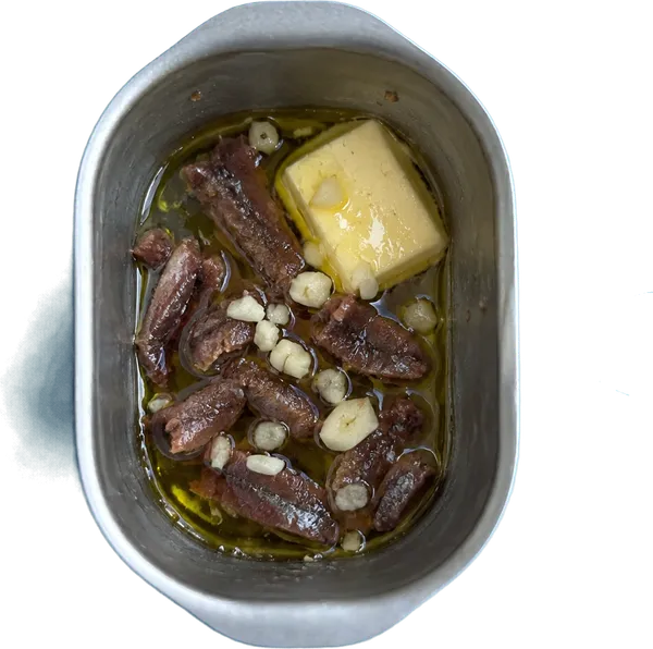 Nel primo contenitore mettete 10 g di olio extravergine di oliva, 10 g di burro, 12 filetti di acciughe sott'olio a pezzetti e 1 spicchio di aglio fresco tritato.