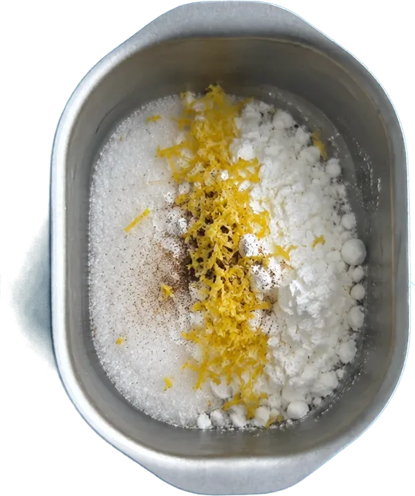 Nel terzo contenitore mettete 110 g di zucchero bianco, 40 g di amido di mais, 0.5 unità di scorze di limone intere e 0.5 bustine di vaniglia in polvere.