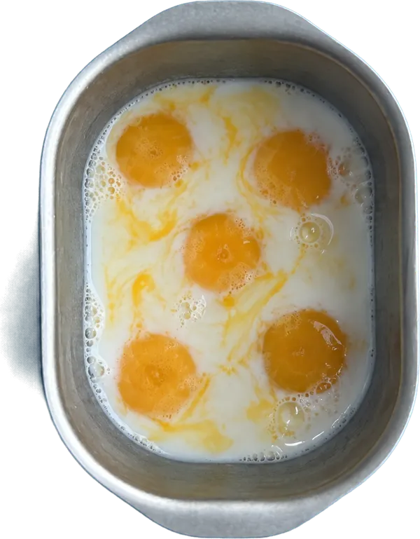 Nel secondo contenitore mettete 150 g di latte vaccino fresco intero e 5 unità di tuorli d'uovo sbattuti.