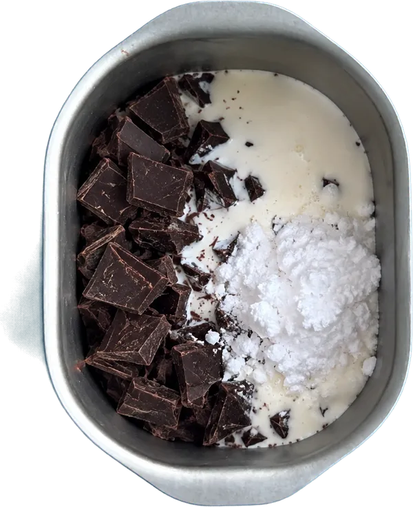 Nel primo contenitore mettete 140 g di cioccolato fondente, 100 g di panna fresca e 60 g di zucchero a velo.