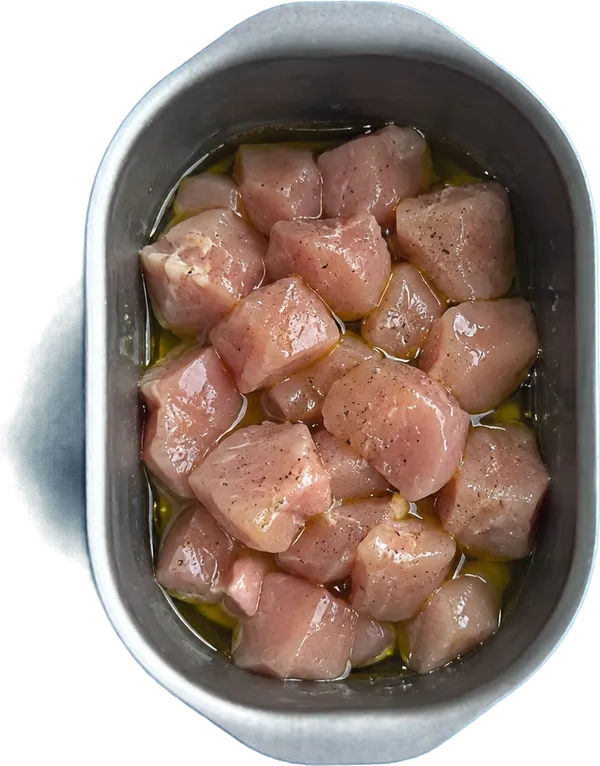 Nel terzo contenitore mettete 5 g di olio extravergine di oliva e 280 g di pollo a dadini medi.